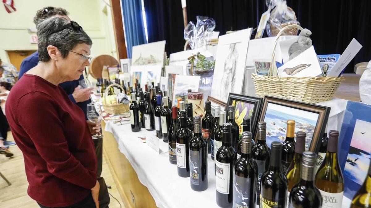 The Cambria Art & Wine Festival returns for its 17th year this weekend. Here, Kathy and Greg Poshepny of Cambria peruse some of the wines being auctioned at last year’s tasting event inside the Cambria Vets Hall.