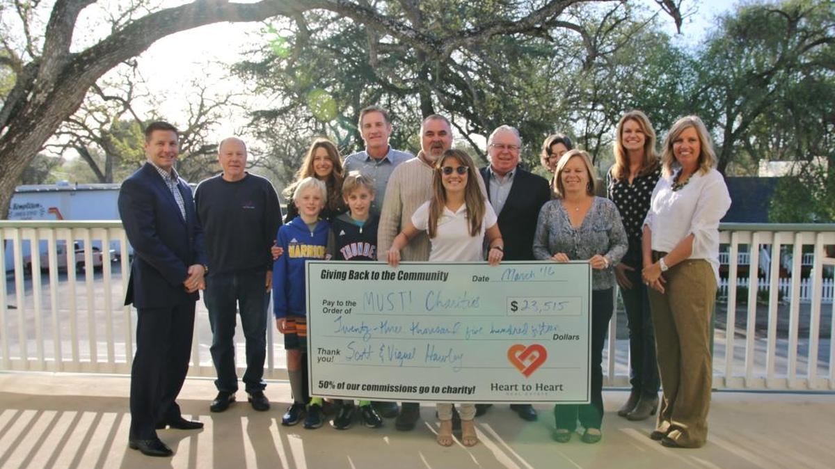Must! charities has received a generous donation from Heart to Heart Real Estate and the Hawley family. Heart to Heart Real Estate owners, the Hawley family and board members of must! charities gather for a celebratory group photo.