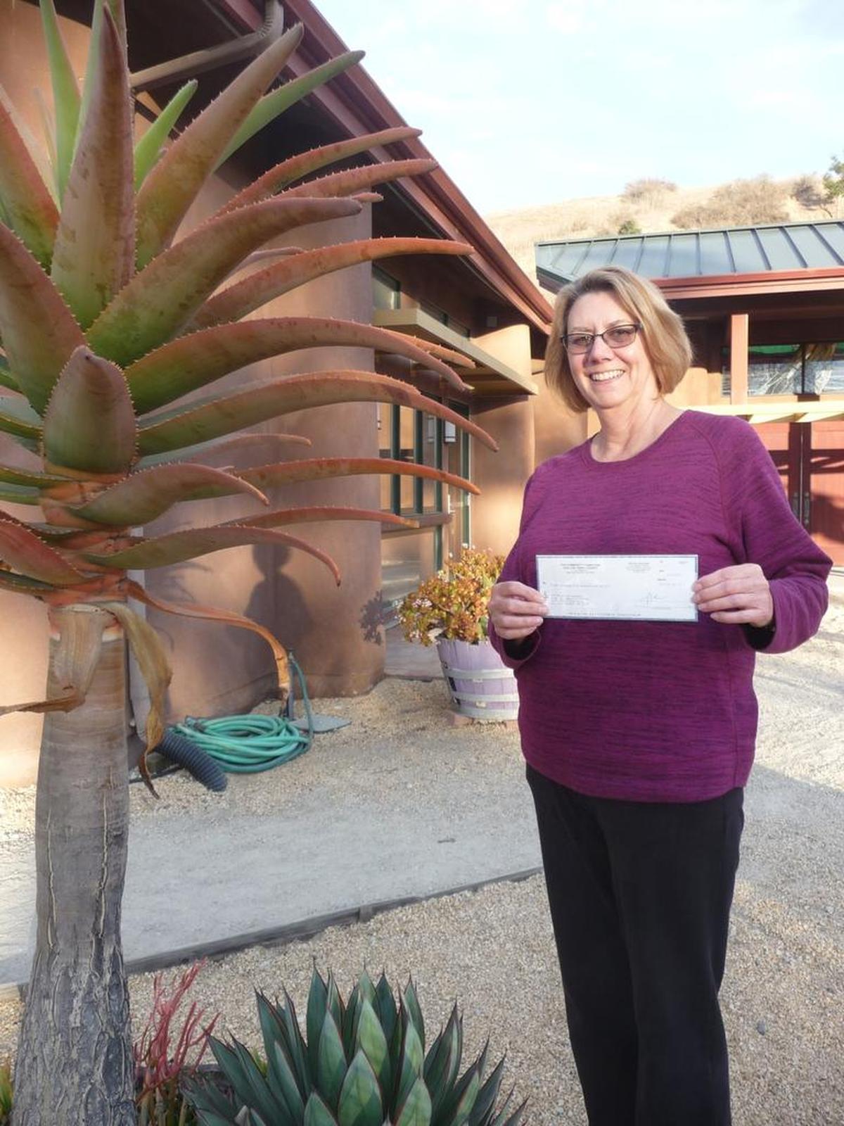 Debbie Hoover, Operations Director of the San Luis Obispo Botanical Garden, displays the recent grant of $2,500 that the garden received from The Community Foundation San Luis Obispo County.