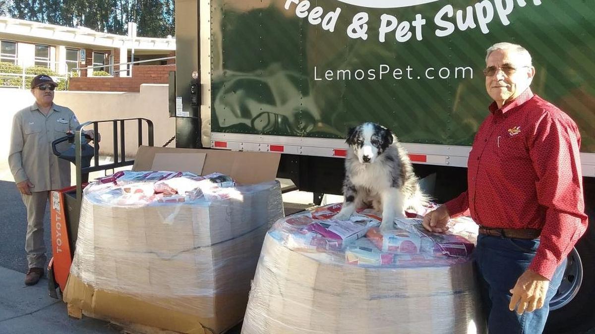 Mike Lemos of Lemos Feed and Pet Supply recently donated $12,000 in dog food to Meals That Connect. Here, Lemos, his dog Jack and his driver Saul Diaz, present the donated dog food.