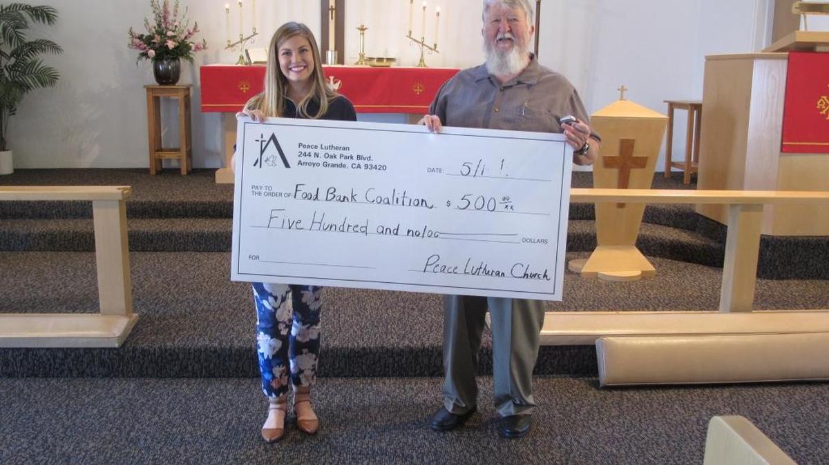 Bert Berringer, right, president of Peace Lutheran Church, presents Caroline Johnson of the Food Bank Coalition of San Luis Obispo County with a check for $500 to feed the hungry. The donation was made possible by members of the Arroyo Grande church.
