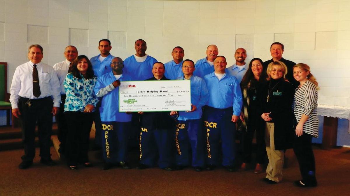 A group of California Men’s Colony inmates (men in blue) recently raised $2,000 for Jack’s Helping Hand. They gathered for a check presentation with, from left, Frank Shaw, Rocco Papietro, Josie Gastelo, Karen Borges, Danny Samuel, Cammie Gonzalez and Jill Gentilly.