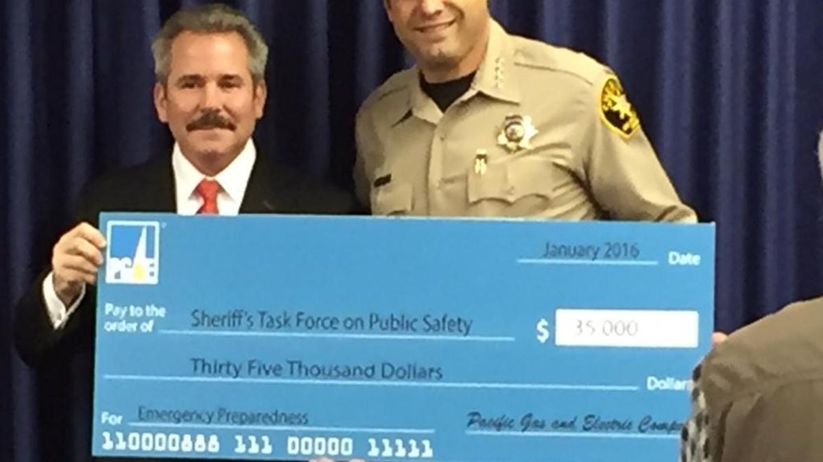 Sheriff Ian Parkinson, right, is presented with a donation to the Sheriff's Public Safety Task Force from PG&E by Ed Halpin, senior vice president of generation and chief nuclear officer for PG&E.