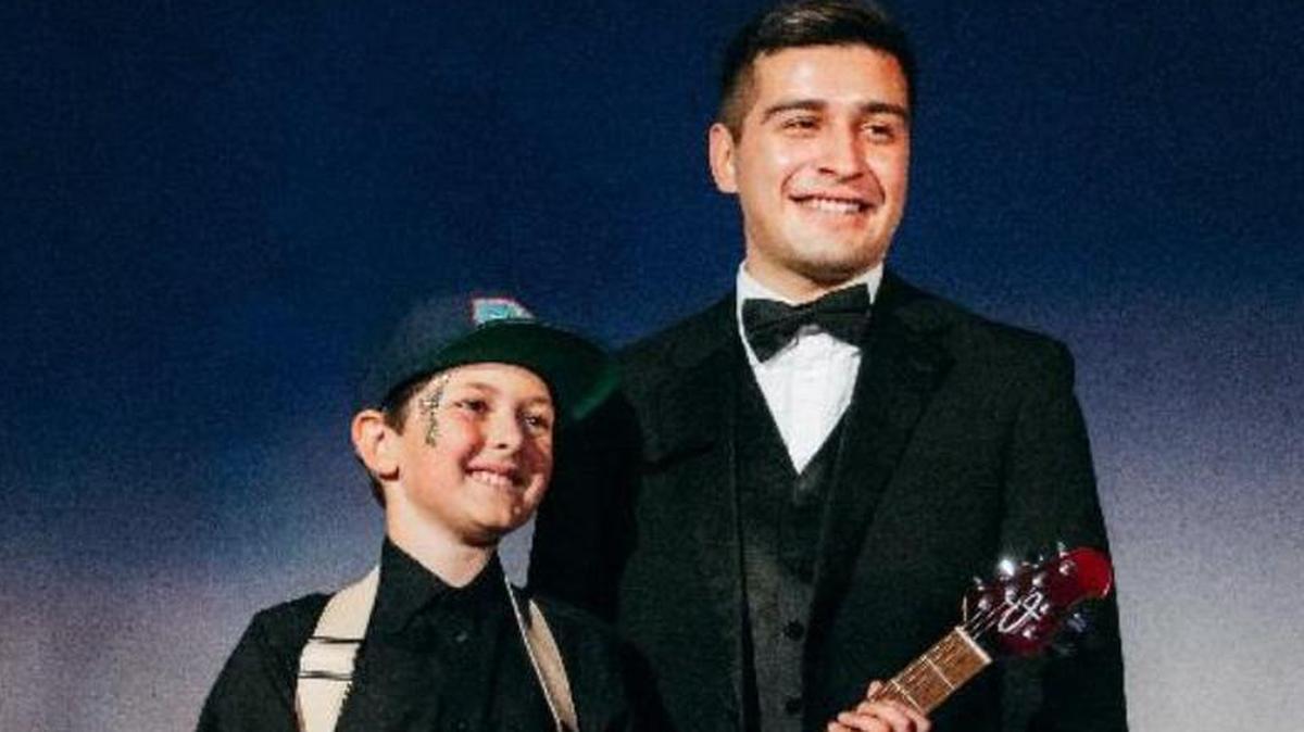 Cooper Hawes and Kiko pose with Cooper’s new Ernie Ball electric guitar.