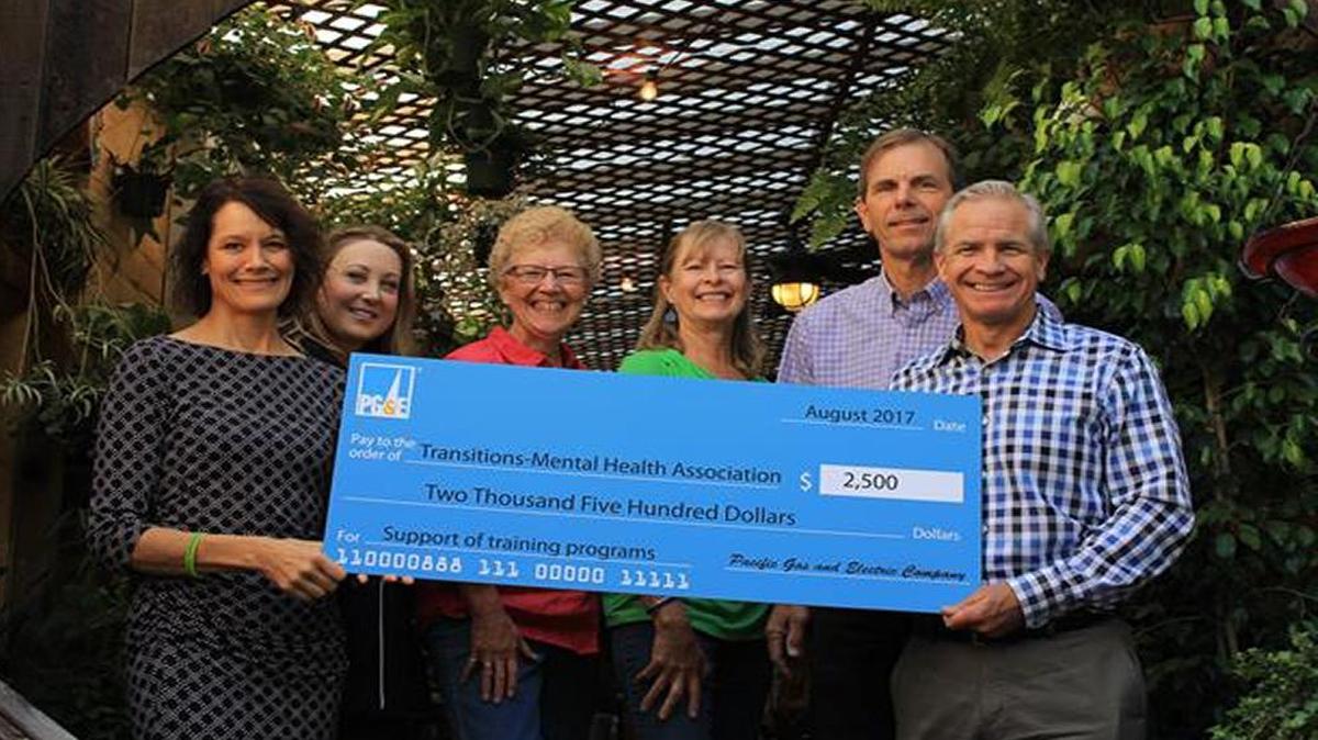 From left, Jill Bolster-White (TMHA executive director), Lindsey Miller (PG&E), Linda Neugent (Growing Grounds Downtown), Christine Story (Growing Grounds Downtown), JT Haas (TMHA board president), Pat Mullen (PG&E region director) smile as a grant check is presented to TMHA.
