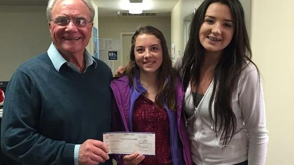 Morro Bay High School FFA members Amanda Weddle, center, and Autumn Boyd, right, present a donation to Carl Hanson, CEO of the Food Bank Coalition of San Luis Obispo County.