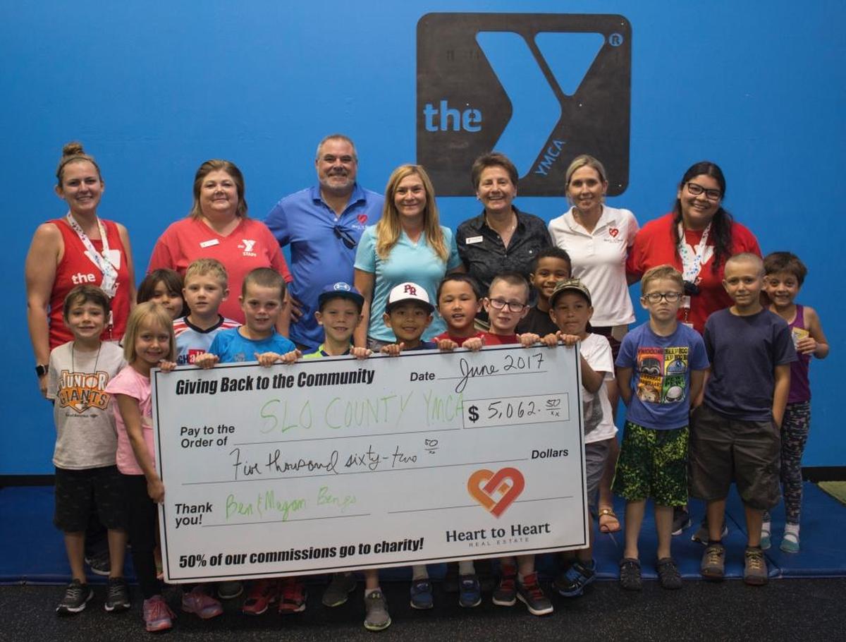 Pictured from left to right: Megan Moerman; Jeri Baxter-Mullins; Mark McConnell, broker/owner of Heart to Heart; Jennifer Young, Realtor, Heart to Heart; Monica Grant, CEO, SLO County YMCA; Christie Giaquinto, Realtor, Heart to Heart; Rosa Morales; and Centennial Park Pioneer Summer Camp participants.