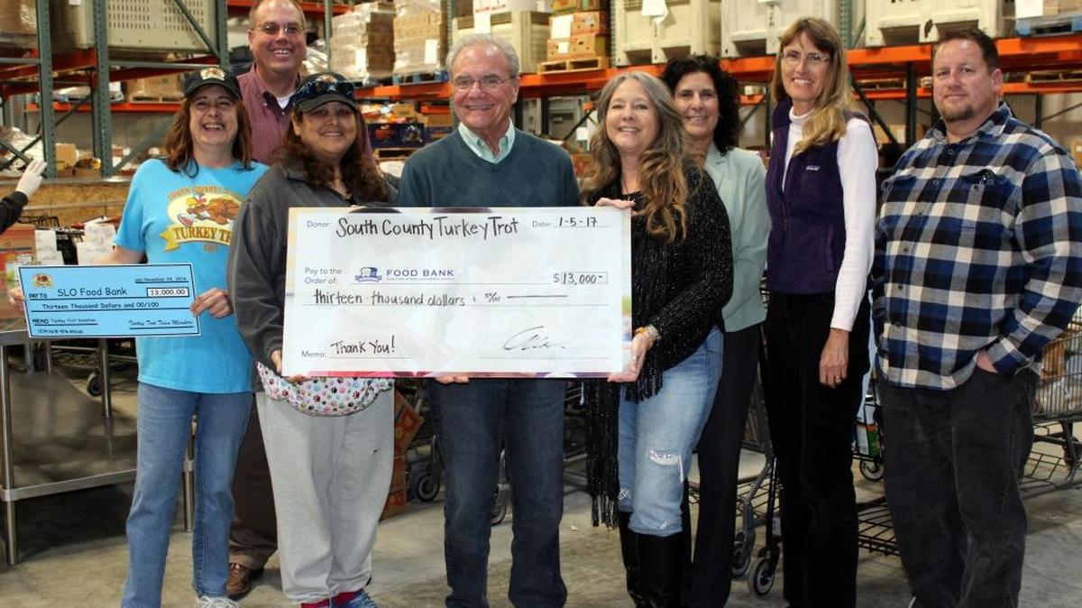 The South County Turkey Trot organizational team, from left, Janis Immel, Sean Schuur, Emma Valdivieso, Carl Hansen, Vivian Krug-Cotton, Donna Milne, Debbie Allen and Kevin Jones (not shown Anthony Salas and Bob Stock) present a check for $13,000 to the Food Bank Coalition of San Luis Obispo County.
