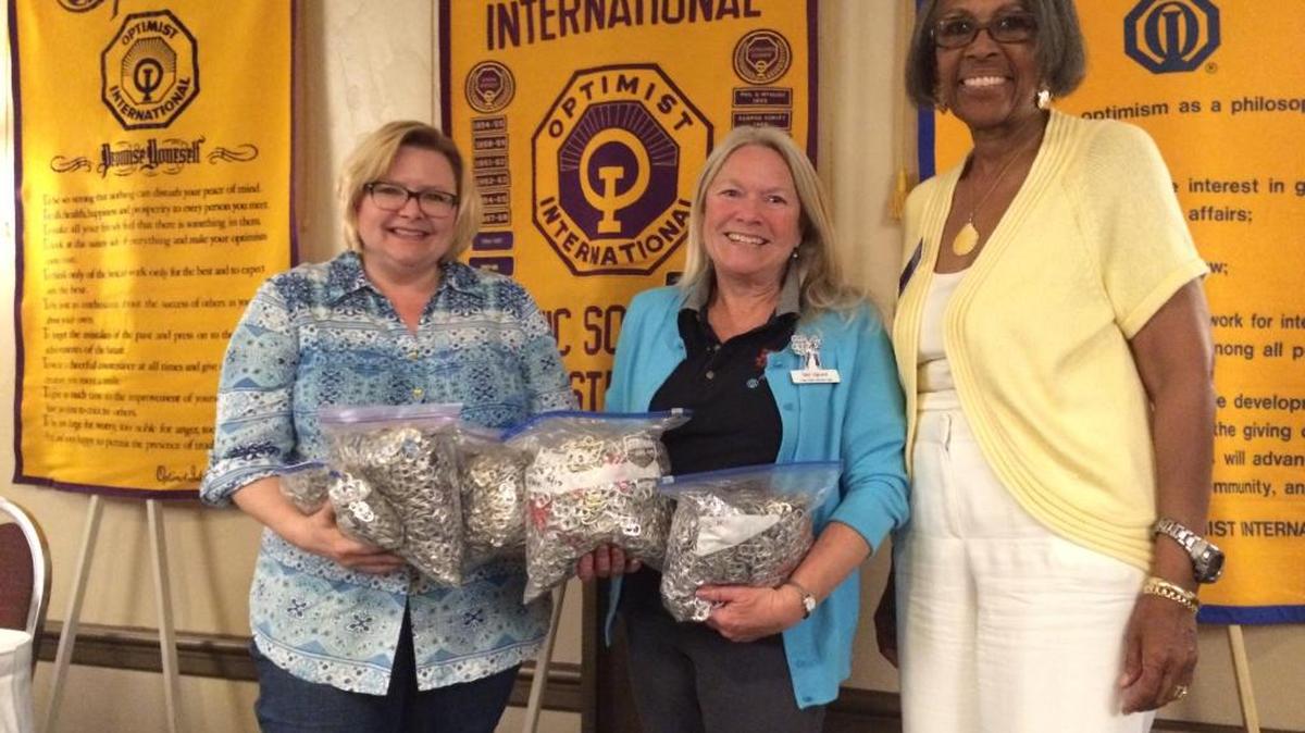 From left, Sarah Orth of Ronald McDonald House Charities and St. Patrick School faculty member Debi Dykzeul hold over 10 lbs. of pull-tabs that third-graders from St. Patrick School collected. Optimist International Governor Carol Morack, right, was also at the presentation.