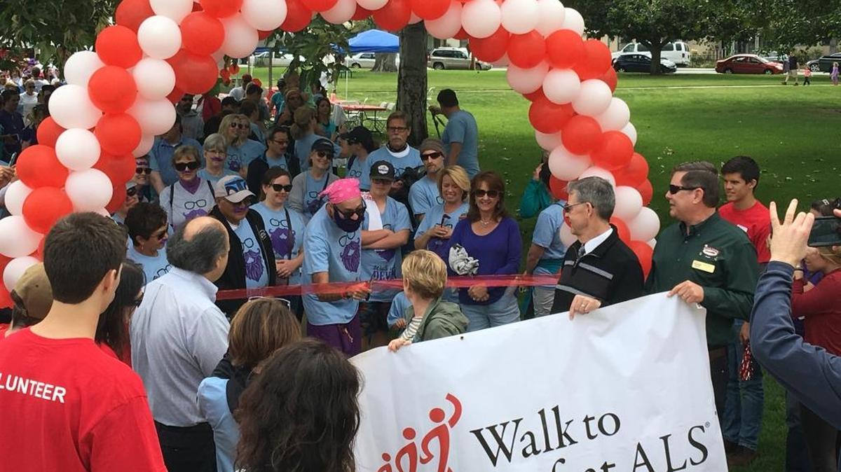Devin Ward, a former teacher who has been diagnosed with ALS, cuts the ribbon to begin the San Luis Obispo County Walk to Defeat ALS, a recent fundraising event at Mitchell Park in San Luis Obispo.