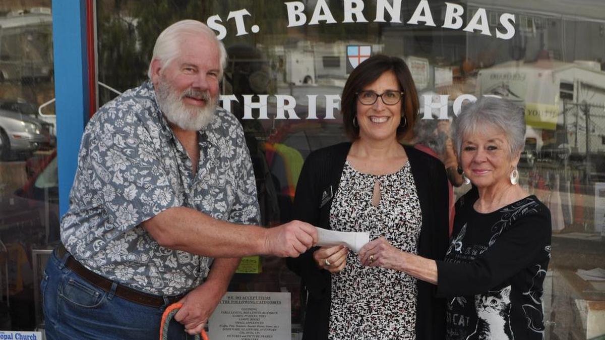 Saint Barnabas Thrift Shop volunteers Robert Merritt, left, Stormi Martel, right, Jinga and Bailee present a check in the amount of $1,254.34 to Susan Olson, Development Director for the Food Bank Coalition of San Luis Obispo County.