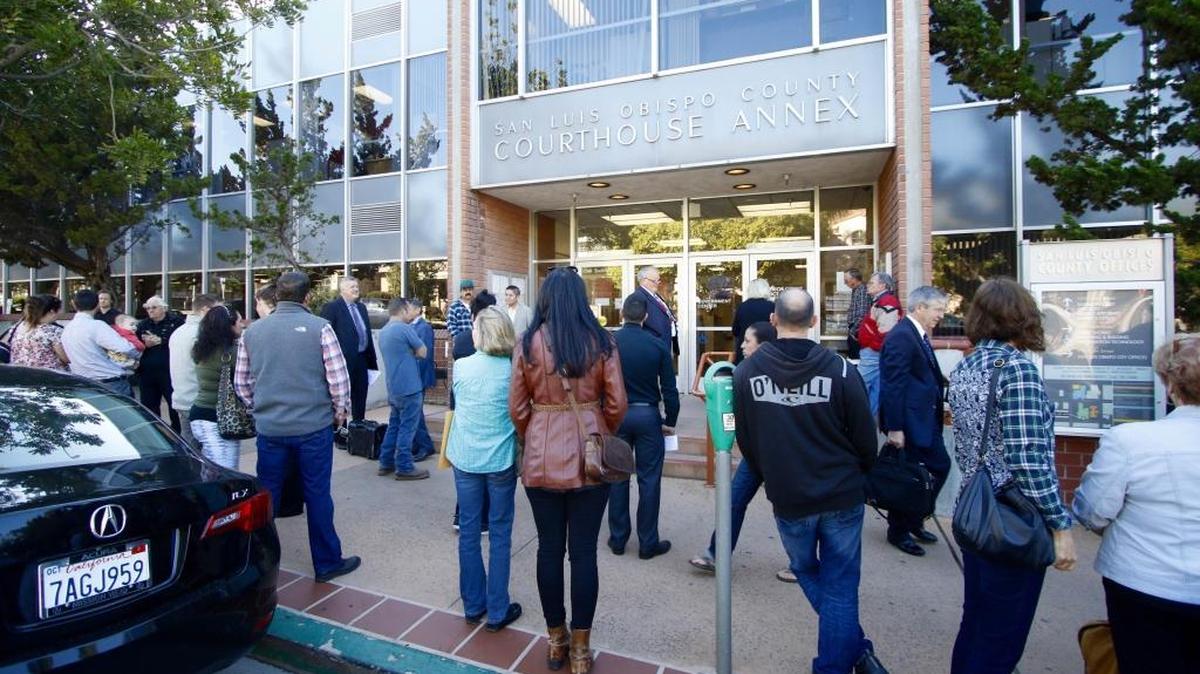 People evacuated from the San Luis Obispo Superior Courthouse wait outside following a threat Wednesday morning.