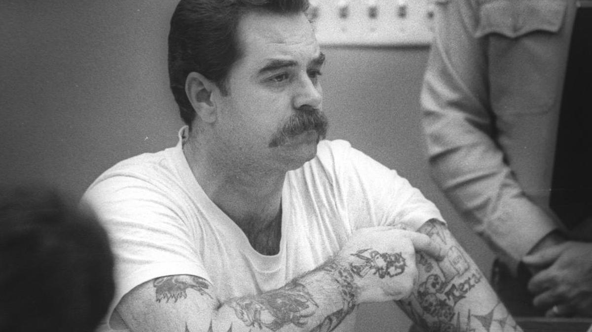 In a July 1988 photo, Dennis Webb points to a tattoo that marks his first murder. He claimed to have murdered five people before being convicted of the murder of John and Lori Rainwater of Atascadero. During the penalty phase of his trial, he took the stand and asked for the death penalty.