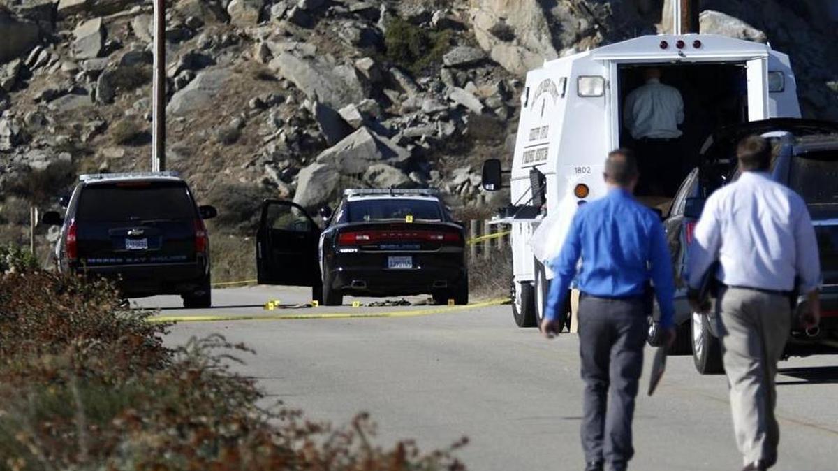 Investigators walk to the site of an officer-involved shooting in Morro Bay in October 2015. Evidence markers can be seen near the police cars.