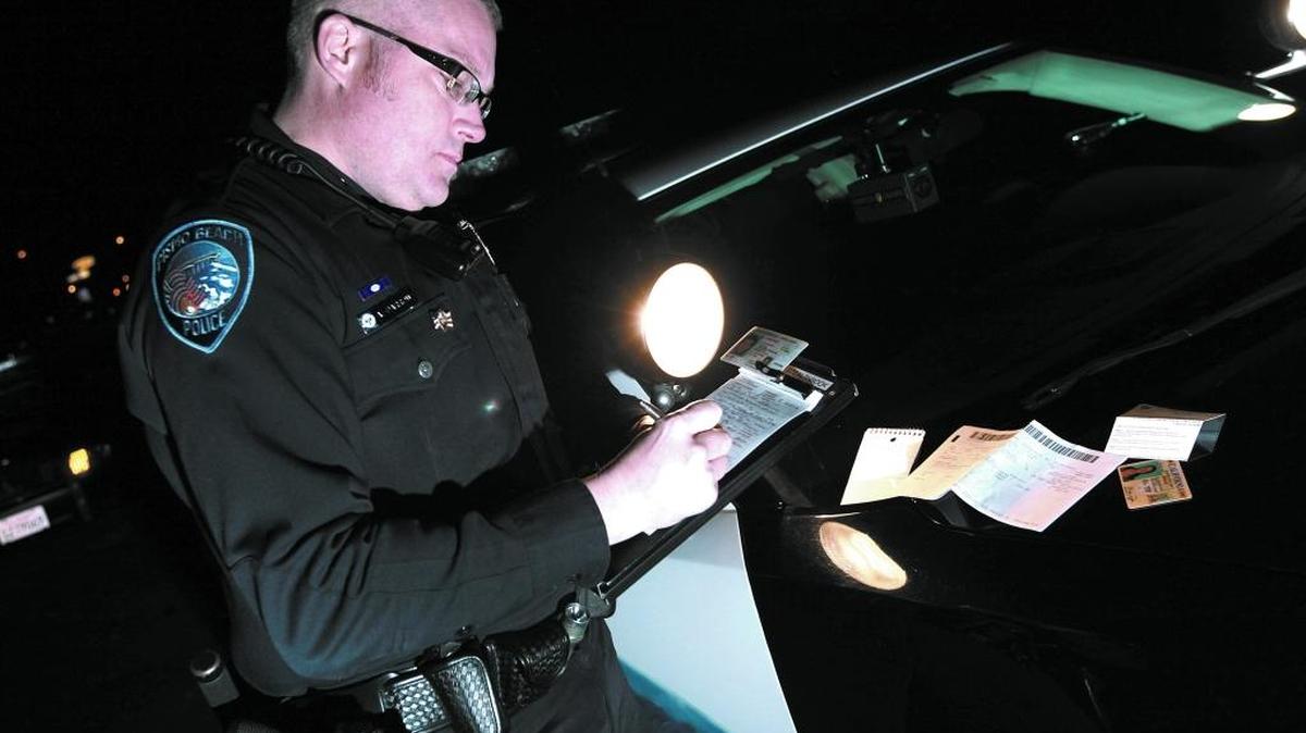 Pismo Beach police Officer Allan Darrow writes a citation in 2012.