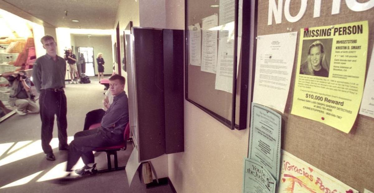 Paul Flores, seated, waits to testify before the county grand jury about Kristin Smart’s disappearance, on Oct. 17, 1996. Flores was the last person seen with Smart. A missing person poster for Smart hangs nearby on the wall of the courthouse.