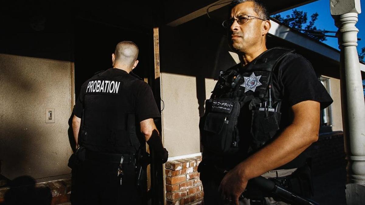 Assistant Chief Probation Officer Robert Reyes, right, keeps a watchful eye as Deputy Probation Officer Isidro Soto enters a sober living facility in Atascadero to check on an AB 109 probationer. The visits are a key part of the post-release program.