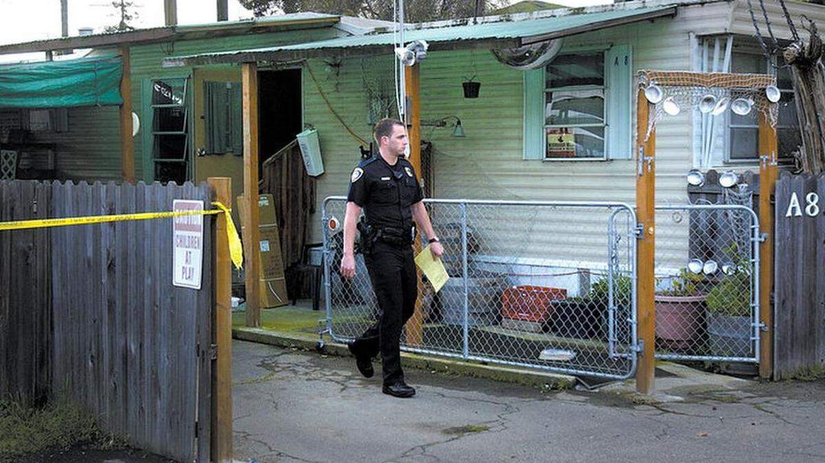 In this March 2005 photo, a San Luis Obispo police officer walks past the home of Gerald O’Malley, who was found dead inside by police.