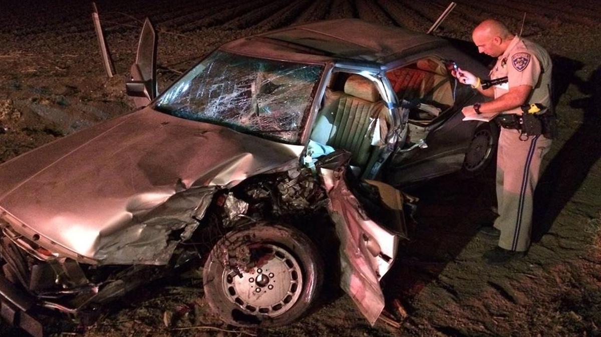 California Highway Patrol officer examines the wreckage of a vehicle involved in a fatal head-on collision the night of Oct. 13 near Lompoc.