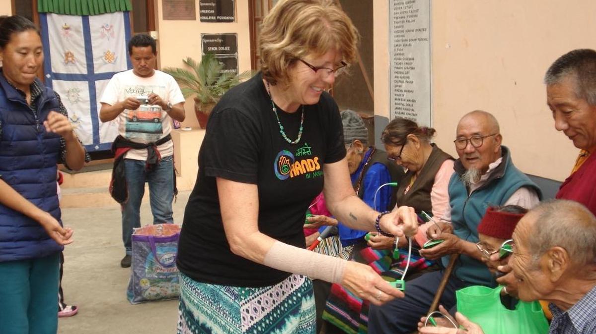 Jan Sprague, who runs the non-governmental organization Hands in Nepal, passes out solar lights to help people in Nepal.