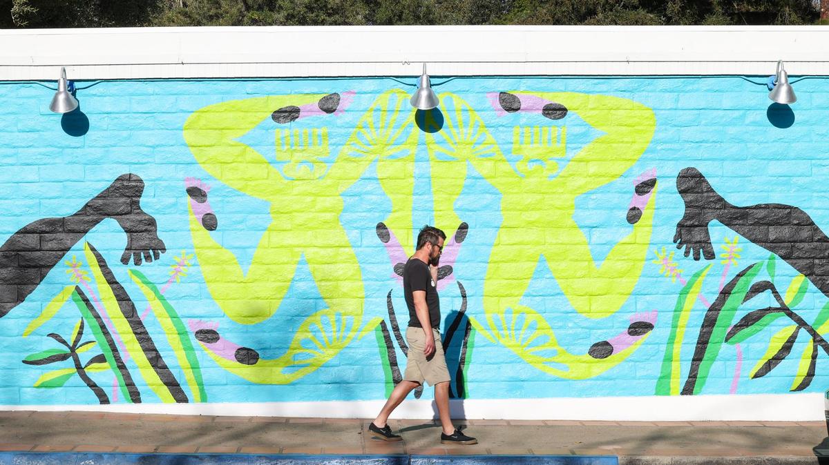 Andrew Webber of San Luis Obispo walks by a mural painted by Erin LeAnn Mitchell and commissioned by the SLO Art Museum. The mural, called “Calafia Was Here,” wraps around the building. The work by Mitchell, of Birmingham, Ala., references the fictional black warrior queen and the unrecorded histories of Black Americans in the West.