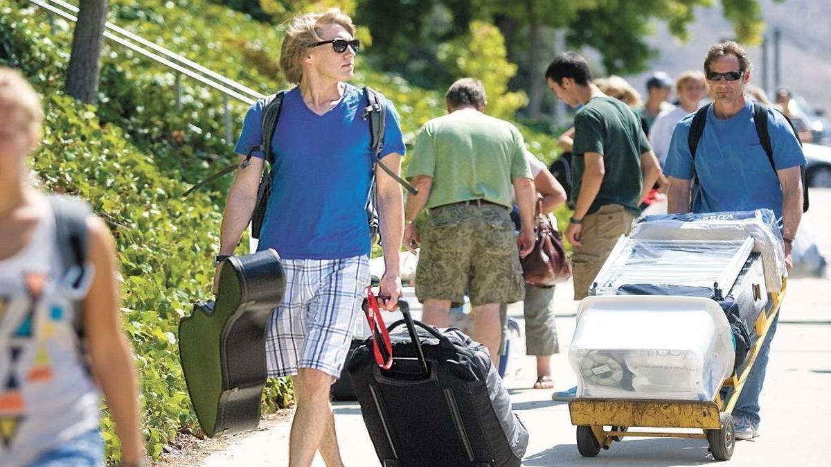 First-year architecture student Tommy Walborn, from San Diego, carrying only his guitar and some clothes prepares to move in to his dorm on campus at Cal Poly in September 2011. His dad, Dave, is carrying the the rest of Tommy’s stuff in the background.