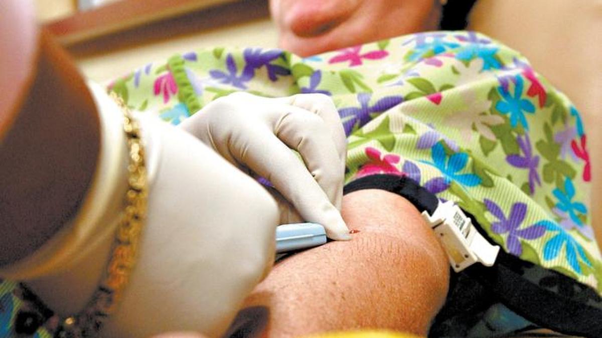 Mary Cavazos of Paso Robles squeezes a toy banana as a needle is inserted in her arm to donate blood at the United Blood Services center in San Luis Obispo in 2006.
