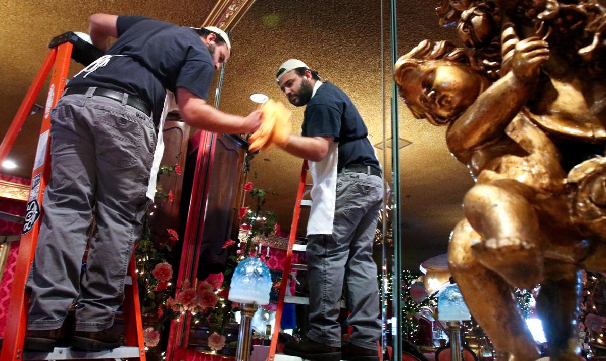Axel Gonzalez cleans a mirror in the Madonna Inn dining room. Staff at the famous San Luis Obispo tourist destination are using the time to get caught up on maintenance during the coronavirus outbreak.