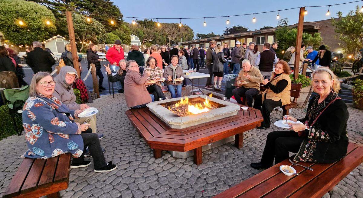 Margaret O’Bryan of Cambria, right, and others enjoy the “Taste of Cambria” fundraiser around the patio fire pit at the Sea Chest Oyster Bar on a chilly, windy evening Tuesday, Nov. 7, 2023.