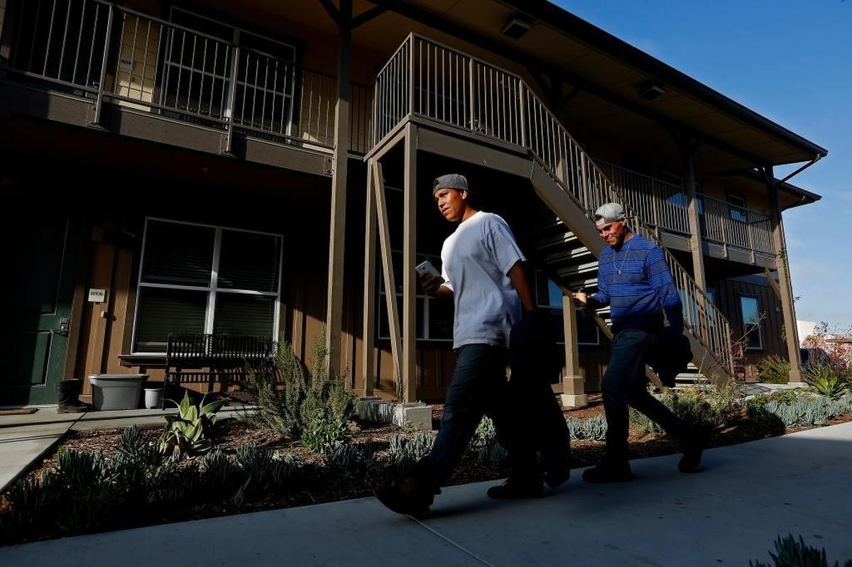 John Ramirez, 20, left, and Henry Murrieta, 22, return to their apartment after working in the lettuce fields near Spreckels. Tanimura & Antle Produce built the Spreckels Crossing housing complex for foreign guest workers, but when the company offered the jobs to all takers, its U.S.-based workers jumped at the chance to pay about $125 a month to share a brand-new two-bedroom suite with as many as seven other workers.