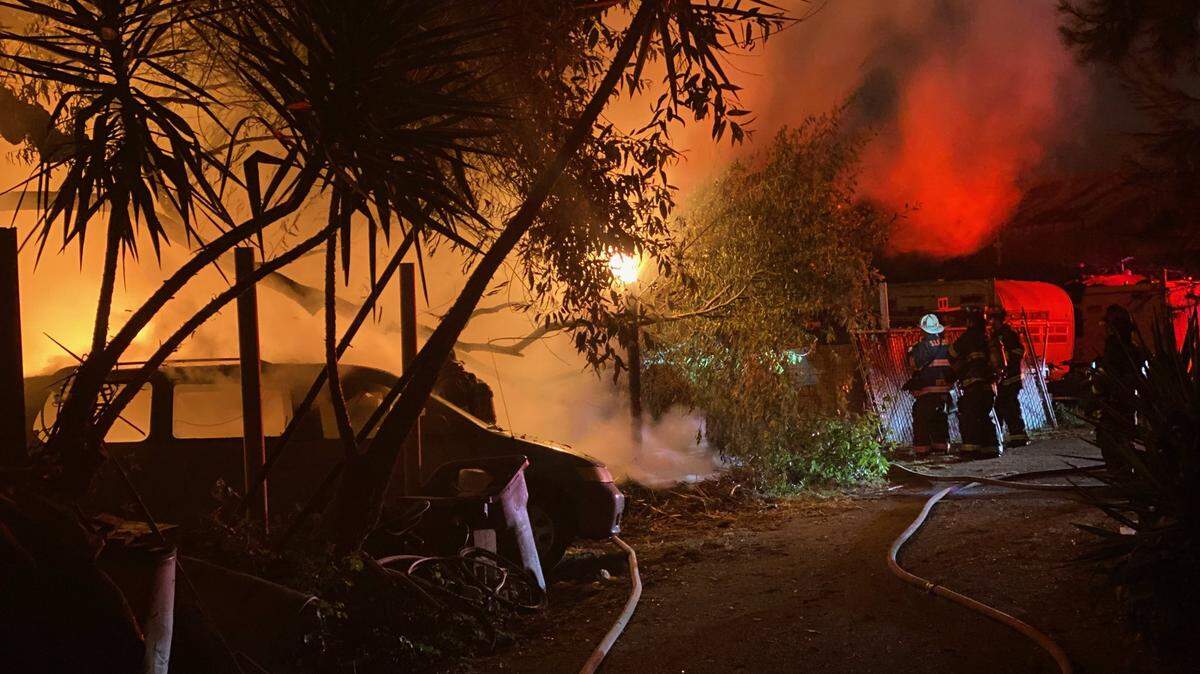 San Luis Obispo City firefighters battle an early morning vegetation fire behind commercial buildings on Prado Road.