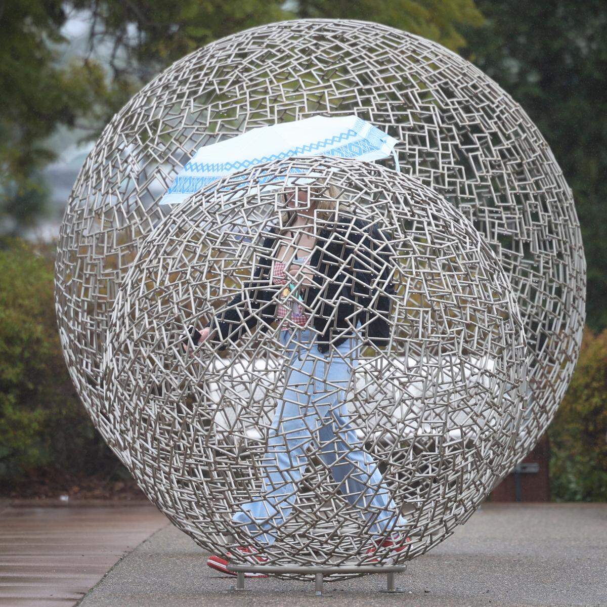 Umbrellas were out at Cal Poly as students and staff walked between sculptures at Performing Arts Center as a rain storm moved in on Feb. 12, 2025.
