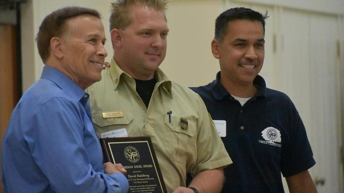 David Dahlberg, a fire prevention technician from the U.S. Forest Service, is flanked by Ray Sweet, left, board president for the Society of St. Vincent de Paul Los Angeles, and Circle V Ranch Camp director Ray Lopez during a “Guardian Angel Luncheon” at Old Mission Santa Inés. The gathering recognized those who helped the campers and staff escape to safety during the Whittier Fire on July 8, 2017.