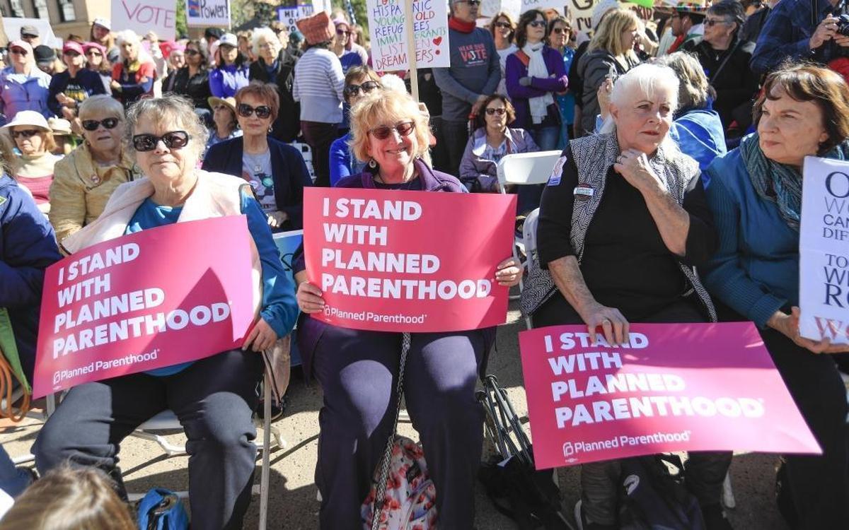 Women’s March San Luis Obispo held a “Hear Our Vote: Voices of Resistance Rally” at Mission Plaza in San Luis Obispo, Saturday, Jan. 20, 2018, about one year after the inaugural Women’s March drew thousands of people to the streets. Holding signs supporting Planned Parenthood are, from left, Meredith Bates and Mary Whiteford of Morro Bay, and Claudette Garcia of Grover Beach.