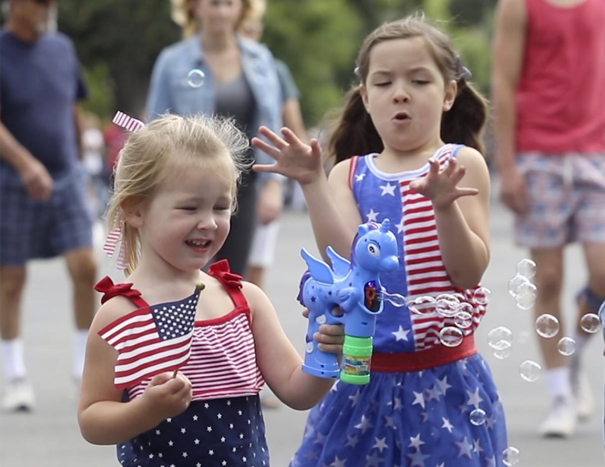 Elyse Erbstoesser, 2, left and Georgia Aguilera, 5, use a bubble maker as Templeton celebreates the Fourth of July at its annual Independence Day Parade in 2018.