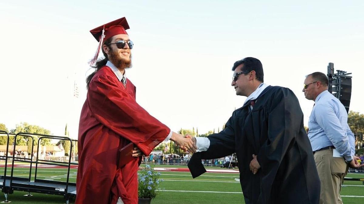 Justin Ruberio shakes Principal Eric Martinez’s hand after receiving his diploma at Paso Robles High School’s graduation ceremony. Martinez announced on Thursday, January 31, 2019, that he will leave the district at the end of the school year.