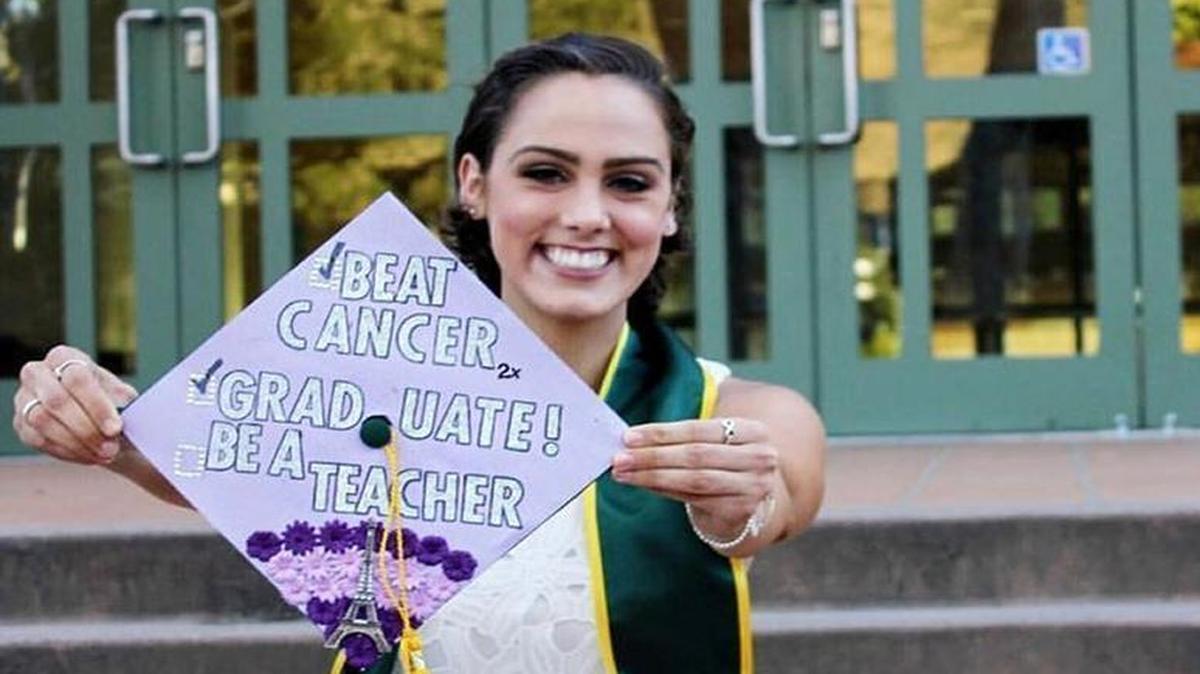 Camille Chabot holds up her mortar board with two of her three goals already accomplished: Beat cancer and graduate. She’ll pursue her third goal — to become a teacher — when she enrolls in the credential program at Cal Poly in the fall.