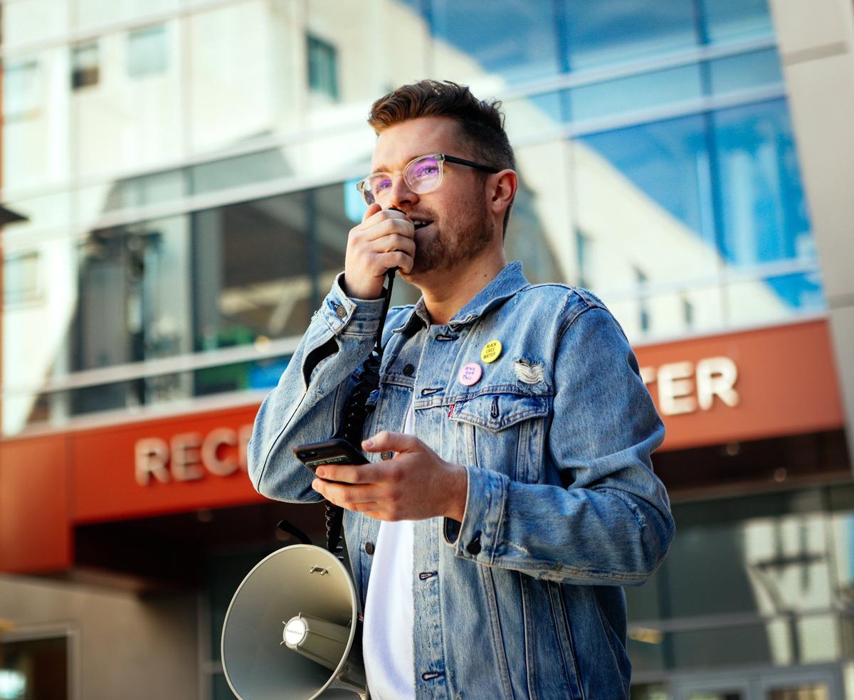 Matt Klepfer, a Cal Poly graduate, speaks at the rally outside of the Cal Poly Career Fair where more than 30 Cal Poly students protested the university’s ties to weapons contractors such as Raytheon, Boeing and Northrup Grumman, urging the university to divest.