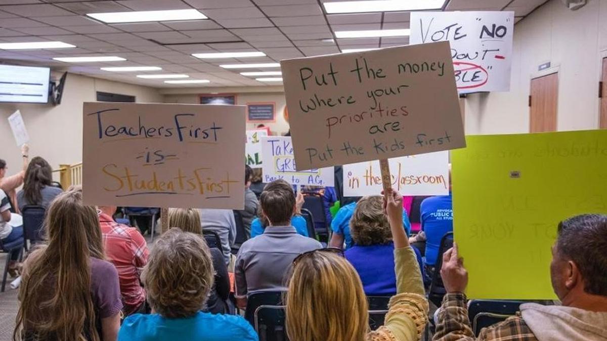 Atascadero Unified School District teachers and parents hold signs during a Board of Trustees meeting on Tuesday, February 6, 2018. The group was protesting a management bonus and expressing their frustration over large class sizes and a lack of funding for classroom supplies.