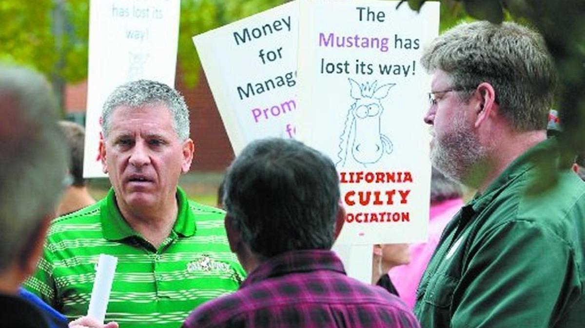 Cal Poly President Jeff Armstrong (left, green shirt) and Cal Poly faculty union president Graham Archer (right, green shirt) convene at a protest in May led by faculty pushing for a pay increase. They disagree on the university’s decision to increase spending on administrative positions in recent years.