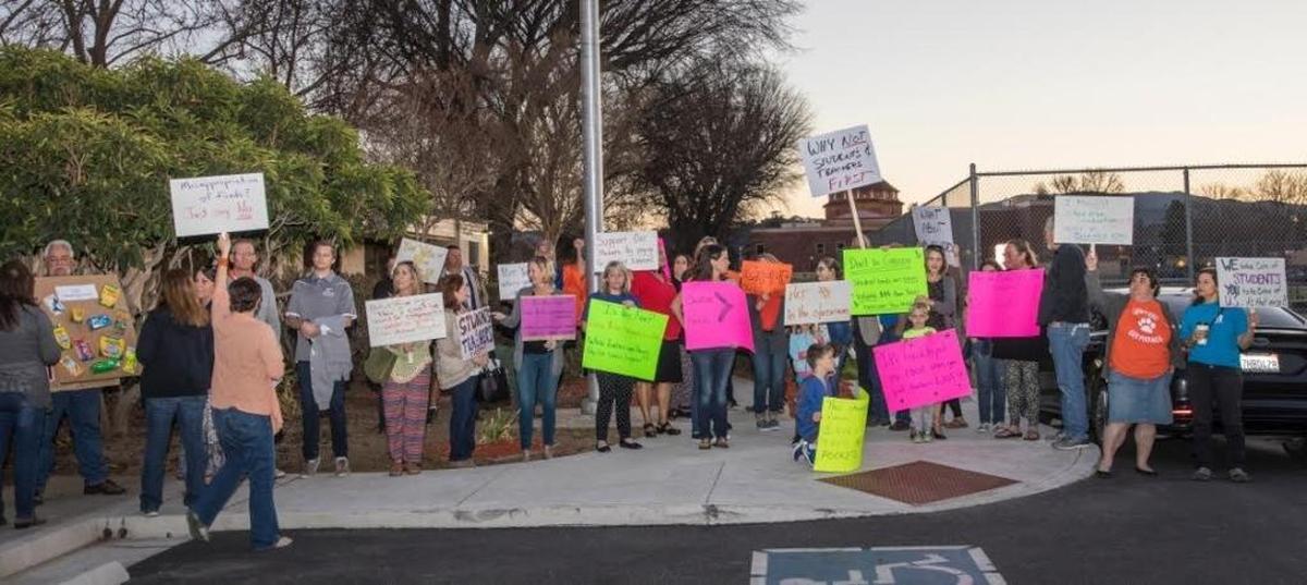Atascadero Unified School District teachers and parents hold signs outside a Board of Trustees meeting on Tuesday, February 6, 2018. The group was protesting a management bonus and expressing their frustration over large class sizes and a lack of funding for classroom supplies.