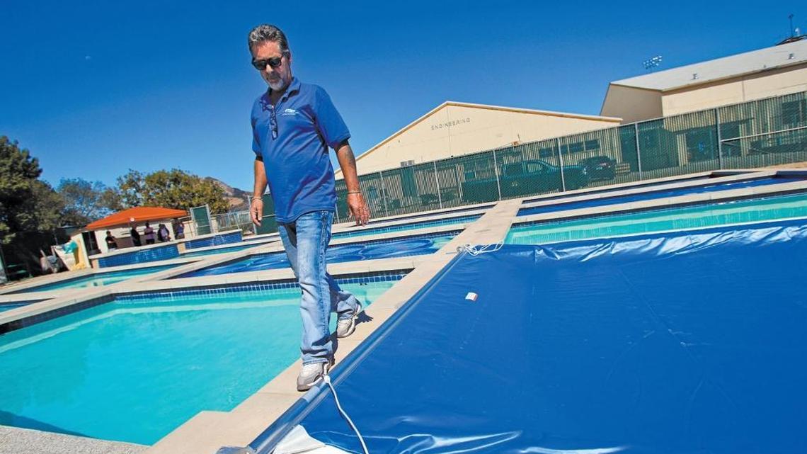 Lee Valenzuela, a board member with the National Plasterers Council, walks past one of several pools at Cal Poly used in a study to determine the effectiveness of pool covers to reduce evaporation.
