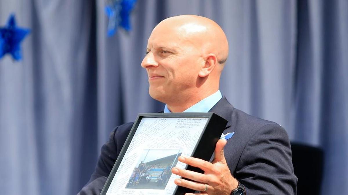 Dan Neff, holds a signed photo that Central Coast New Tech students gave him at the senior graduation in 2016.