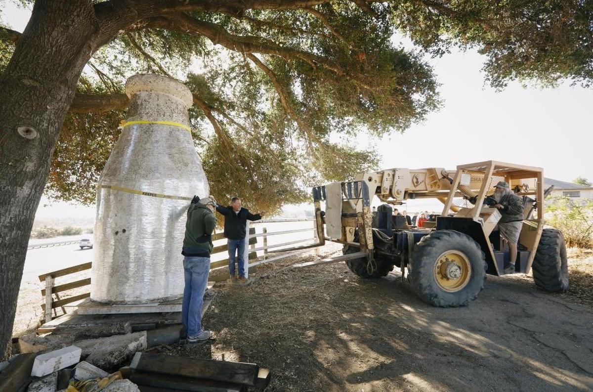 The Templeton Historical Society moves a giant stucco milk bottle once used to advertise the Rossi family’s Crescent Farm to its new home at the museum on Main Street on Tuesday.