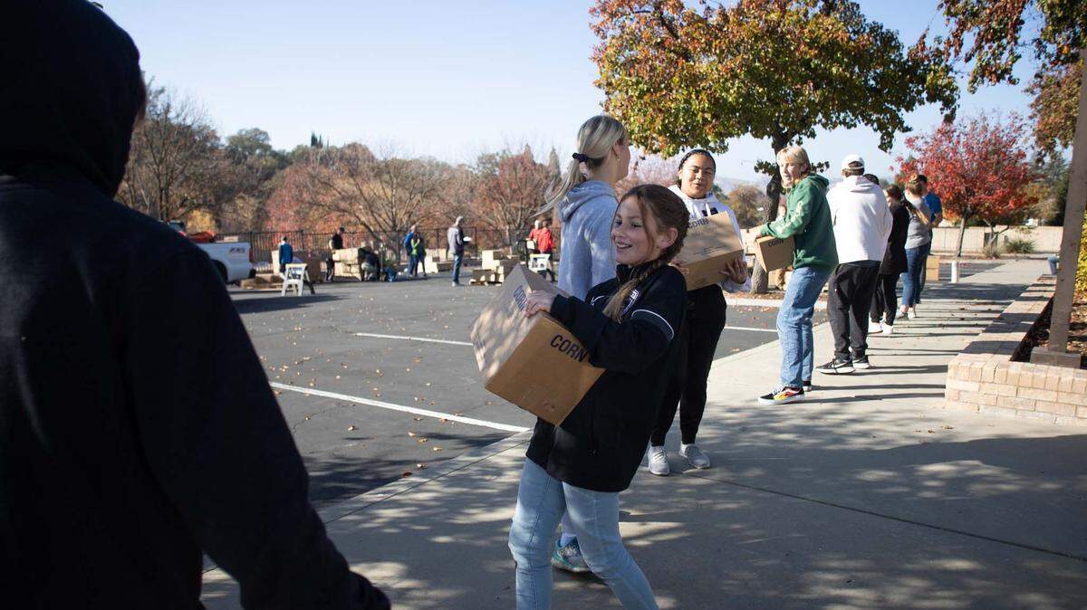 11-year-old Kaylyn Butterfield helps the Church of Jesus Christ of Latter-day Saints unload 24 pallets of food from a semi truck at the Paso Robles location on Tuesday Nov 22, 2022.