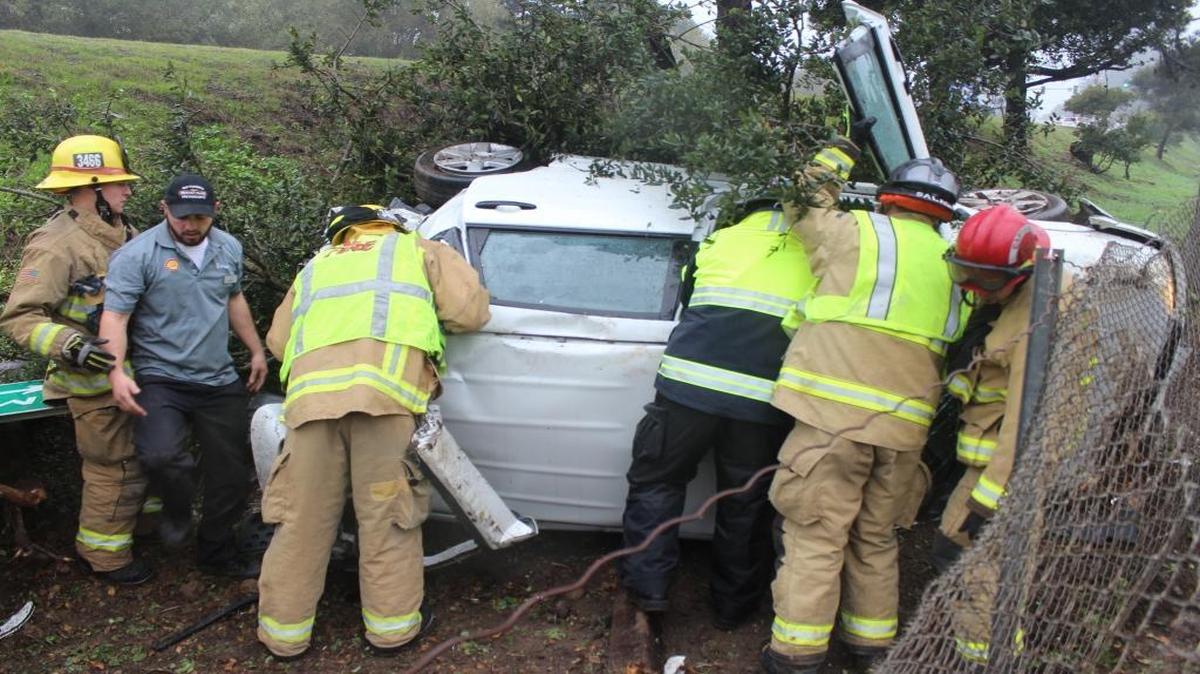 Firefighters assist with a single-car rollover crash just west of Main Street in Cambria Sunday afternoon.