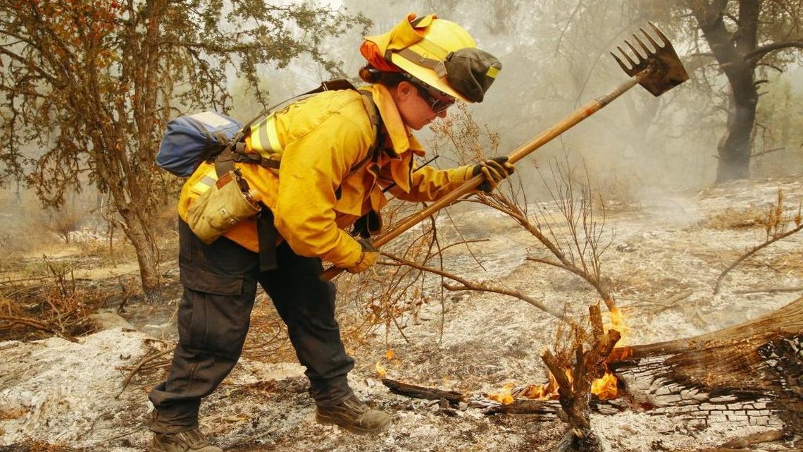 Firefighter Kristen Johnson, with the Riverside Fire Department, works to mop up a burned area along Lynch Canyon Road during the Chimney Fire on Aug. 23, 2016.