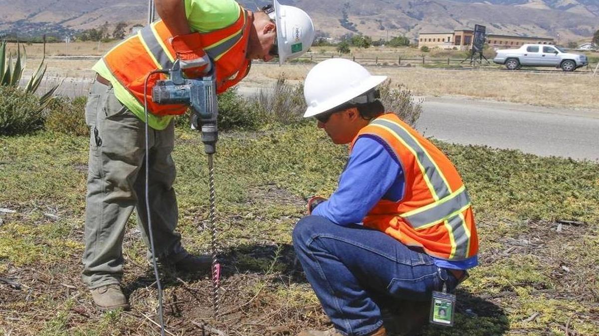 Greg Mortka, left, and Mark Nishibayashi install a passive soil gas probe near the fire station at the San Luis Obispo County Regional Airport in July. Areas of the airport were tested for the toxic solvent TCE to find the source of groundwater contamination.