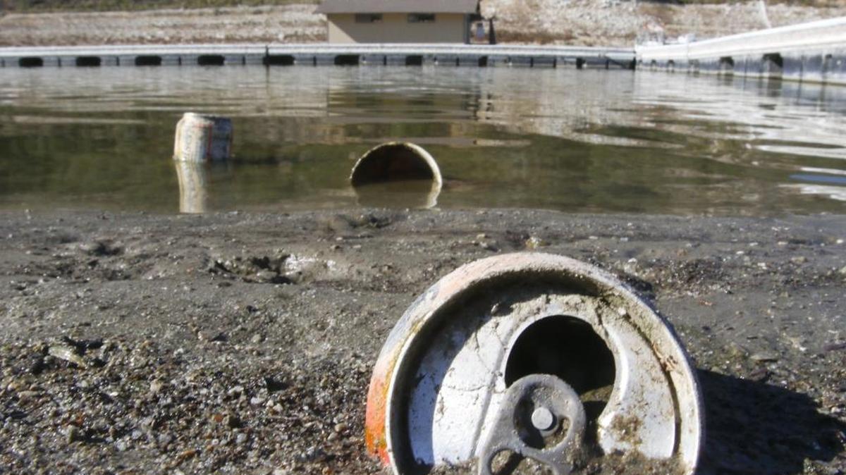 The falling Lopez Lake water line is exposing once-submerged trash. Drink cans and bottles appear to be the majority.