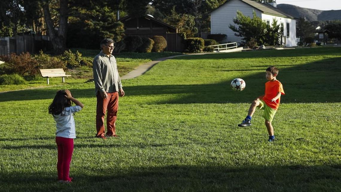 Javier de la Fuente plays soccer with his kids Mia, 5, and Lucas, 9, on the central lawn area of Los Osos Community Park. A dog park is planned for the north side of the park, behind the tennis courts.